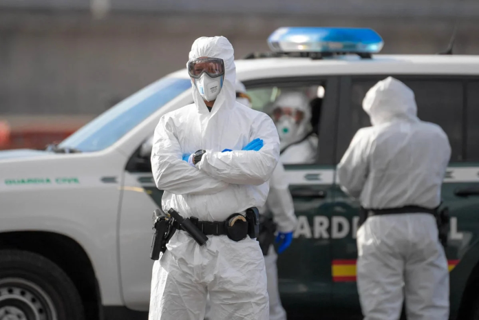 Agente della Guardia Civil in tenuta biocontenimento durante un'operazione sanitaria in Spagna.